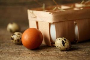 Chicken and quail eggs on a wooden rustic background photo