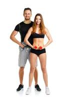 Sport couple - man and woman with dumbbells on the white photo