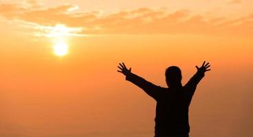 Silhouette of woman raising her hand praying spirituality and religion, banner and copy space of female worship to god. Christianity religion concept.Christians person are pray humility humble to god. photo