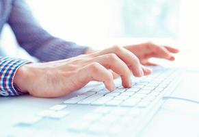 Male hands or men office worker typing on the keyboard photo