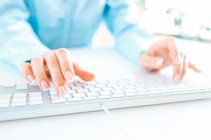 Woman office worker typing on the keyboard photo