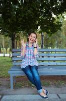 A portrait of a smiling beautiful woman in the park talking on the phone photo