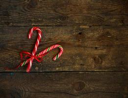 Closeup of two old fashioned candy canes on a rustic wooden background photo