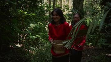 Young woman in red traditional clothes and long black hair walking together with friends in the forest video