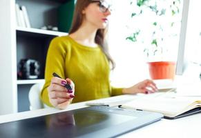 Artist drawing something on graphic tablet at the home office photo