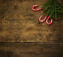Christmas tree branches with candy canes on wooden texture ready for your design photo