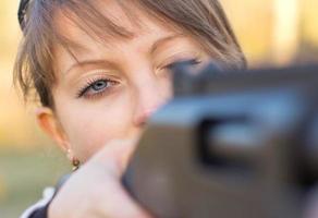 niña con un pistola para trampa disparo y disparo lentes puntería a un objetivo foto