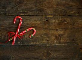 Closeup of two old fashioned candy canes on a rustic wooden background photo