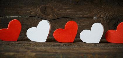 Red and white hearts on old wooden background photo