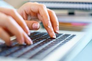 Closeup female hands on laptop keyboard photo