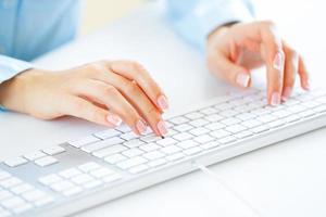 Woman office worker typing on the keyboard photo