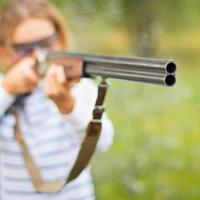 un joven niña con un pistola para trampa disparo foto