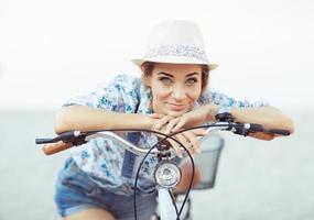 contento mujer con bicicleta en el playa foto