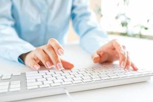 Woman office worker typing on the keyboard photo