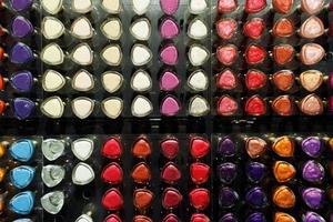 Set of different nail varnishes on shelves in cosmetic store photo