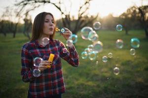 Woman blowing bubbles outdoors photo