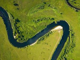 Top view of the Seim River, Ukraine, surrounded by trees and meadows on its banks, view from the top