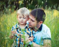 Father and his baby son having fun in the park outdoor photo