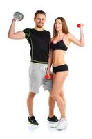 Athletic man and woman with dumbbells on the white photo