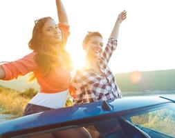 Two young girls having fun in the cabriolet outdoors photo