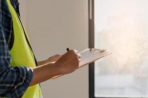 edificio inspección, contratista asiático joven hombre, masculino inspeccionando hogar, reconstruido construcción, renovación o cheque defecto, antes de terminar entrega eso terminado a cliente. Ingenieria obrero, Copiar espacio. foto