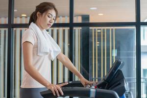 rutina de ejercicio mujer, chica, ejercicio en elíptico cruzar entrenador en ajuste ropa de deporte, práctica trabajando fuera formación para salud. deporte fuerte persona en gimnasio aptitud para sano estilo de vida, recreación concepto. foto