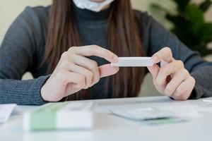 pandemia de enfermedad, asiático joven mujer, niña mano participación atk, antígeno equipo yo prueba. presentando dispositivo nasal, nariz torunda prueba para posible infección de coronavirus, covid-19 a hogar. salud cuidado. foto