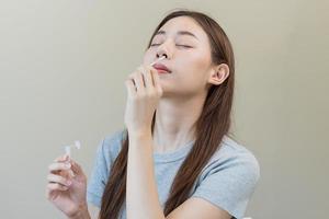 pandemia de enfermedad, asiático joven mujer, niña mano participación atk, antígeno equipo yo prueba. presentando dispositivo nasal, nariz torunda prueba para posible infección de coronavirus, covid-19 a hogar. salud cuidado. foto