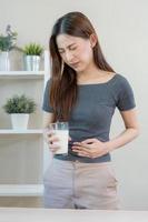 Pain, Allergy asian young woman, girl hand in belly suffer after drink glass of milk, suffer and bad stomach ache. Lactose intolerance and dairy food , health problem concept. photo