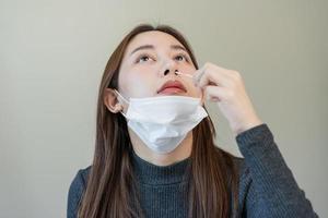 pandemia de enfermedad, asiático joven mujer, niña mano participación atk, antígeno equipo yo prueba. presentando dispositivo nasal, nariz torunda prueba para posible infección de coronavirus, covid-19 a hogar. salud cuidado. foto