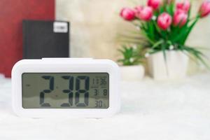 Digital clock with book decorated on table photo