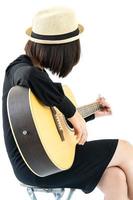 Woman sitting and playing guitar guitar folk song in her hand photo