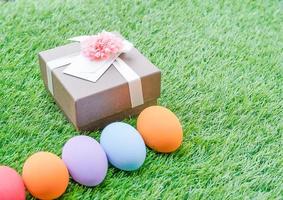 Easter eggs on grass and gift box photo