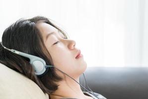 mujer joven escuchando música desde el teléfono móvil foto