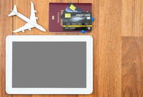 Top view Passport with credit card and digital tablet mock up on wooden desk photo