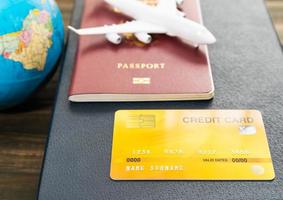 Credit card and airplane model on wooden table photo
