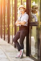 Women wearing hat standing in front of a glass building photo