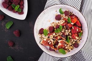 Chia seed pudding made with raspberries,  figs and mint on dark background.  The concept of good nutrition. Top view photo