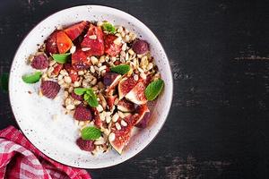 Chia seed pudding made with raspberries,  figs and mint on dark background.  The concept of good nutrition. Top view photo