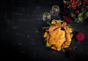 Baked turkey or chicken. The Christmas table is served with a turkey, decorated with bright tinsel. Fried chicken. Table setting. Christmas dinner. Top view photo