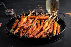 Baked organic carrots with thyme, honey and lemon. Organic vegan food. photo