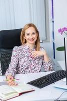 Beautiful businesswoman working on a laptop. Female freelancer connecting to internet via computer. Blogger or journalist writing new article. photo