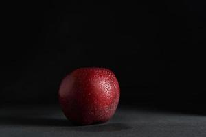 Red juicy freshness Apple with drops of water on a Black Background. Isolate. Copy space photo