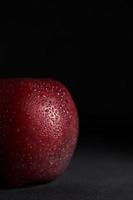 Red juicy Apple with drops of water on a Black Background. Isolate. Copy space. Close up photo