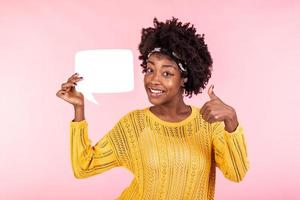 Young and beautiful woman holding white speech bubble board and showing OK sign. African american girl wears casual outfit . Happy feelings and positive energy concept. photo