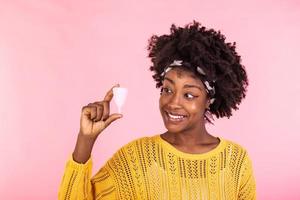 Portrait of woman holding menstrual cup isolated over pink studio background, happy female having period, dislike to use napkins or tampons. Women health concept, zero waste alternatives photo