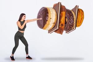 Fit young woman saying NO to sweets and candy, Fit young woman saying NO to unhealthy carbohydrates photo