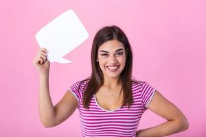 Portrait of a happy young beautiful woman holding empty speech bubble isolated over pink background photo