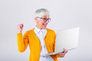 Happy mature middle aged elderly business woman winner excited by reading good news looking at laptop, glad senior older lady watching celebrating online bid bet win or great result victory concept photo