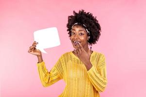 Young and beautiful woman holding white speech bubble board. African american girl wears casual outfit . Happy feelings and positive energy concept. photo